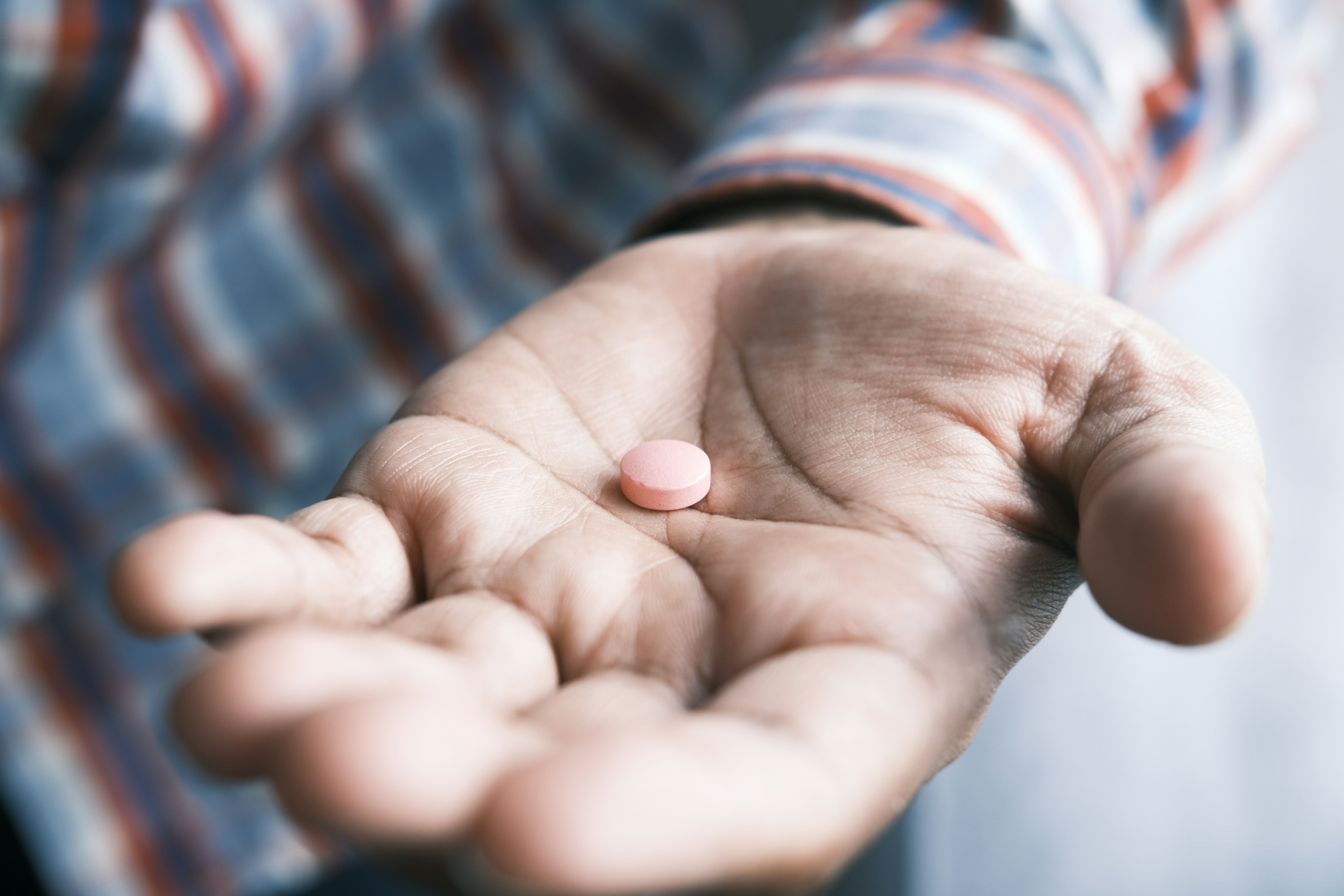 Close up of man hand holding pills